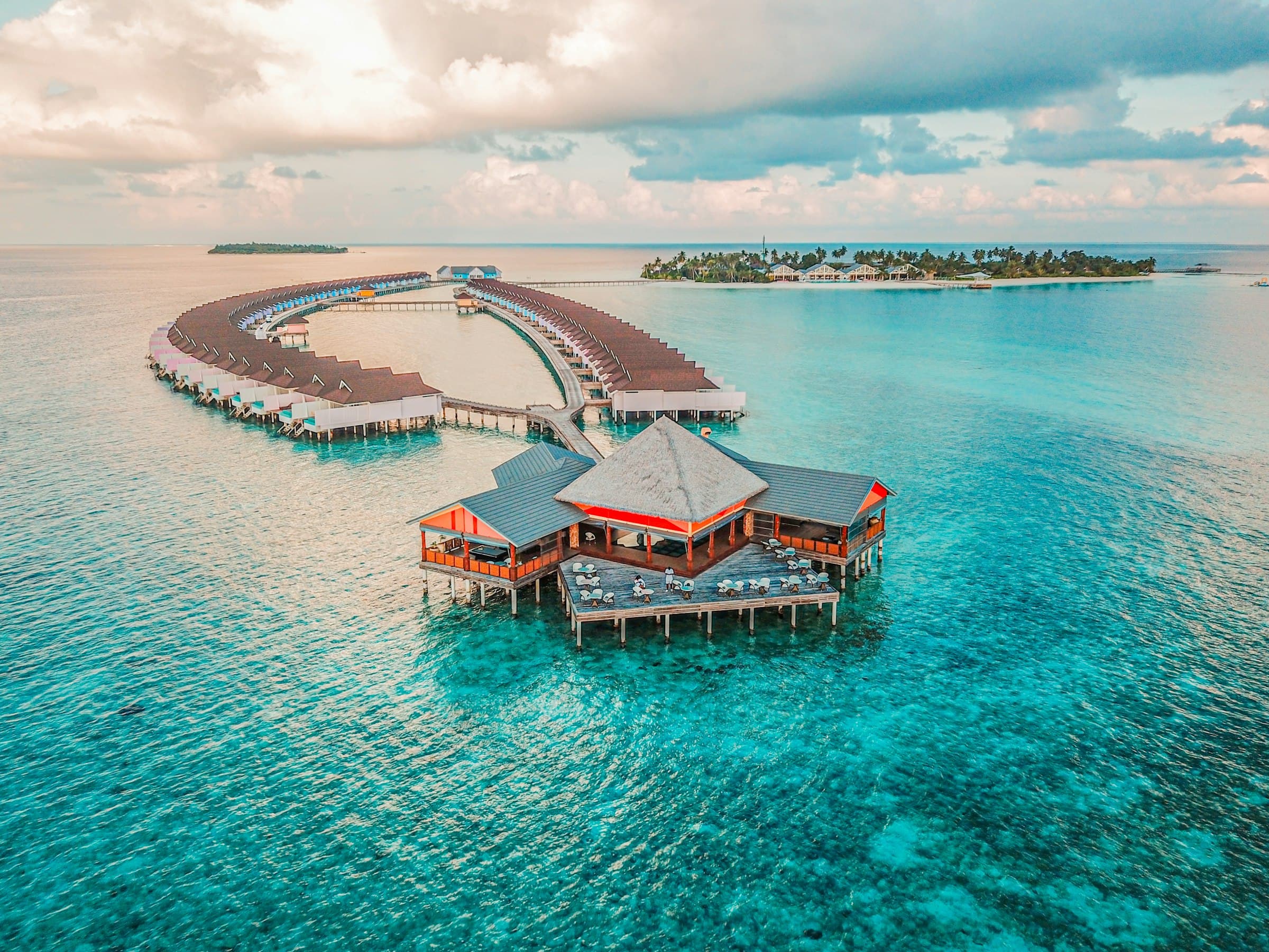 Aerial view of Niva Velassaru, overwater villas radiating from the resort island.