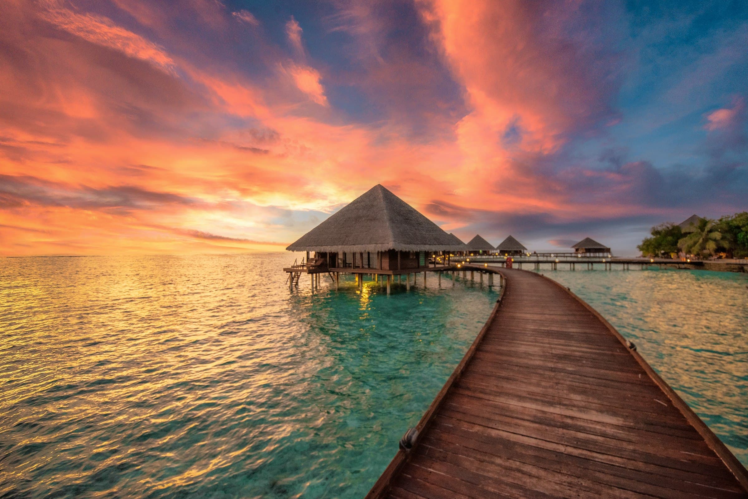 Overwater bar at sunset, the service moment the programme is built around.